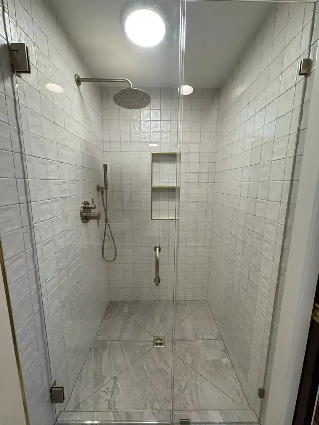 Walk-in shower conversion with white handmade-look tile, rainfall head, grab bar and a frameless glass panel